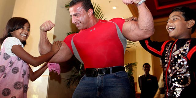 New York-based Lebanese body builder George Farah, center, poses with "Slumdog Millionaire" child stars Azharuddin Mohammed Ismail, right, and Rubina Ali when they happen to meet at a hotel in Mumbai, India.