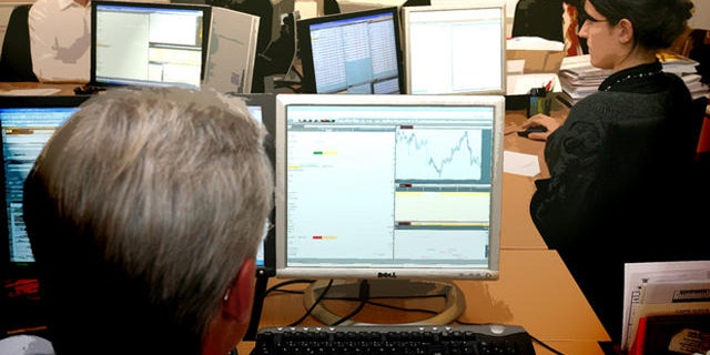 Employees of Montsegur Finance, a portfolio management company authorized by the Financial Markets Authority, work at their desk in Paris, Monday, Jan. 21, 2008. France's stock markets plunged on Monday following declines on Wall Street last week amid investor pessimism over the US government's stimulus plan to prevent a recession. France's CAC 40 slid 6.1 percent, but it was not the only European country to see a significant drop. Germany's DAX was down 6 percent in morning trading, while Britain's FTSE 100 dropped 5.1 percent. (AP Photo/Thibault Camus)