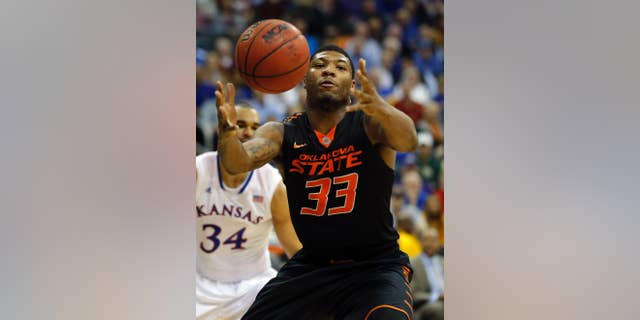 FILE - In this March 13, 2014 file photo, Oklahoma State guard Marcus Smart (33) reaches for the ball during the second half of an NCAA college basketball game against Kansas in the quarterfinals of the Big 12 Conference men's tournament in Kansas City, Mo. Oklahoma State (21-12), the No. 9 seed in the West Region, will play No. 8 seed Gonzaga (28-6) Friday, March 21, 2014, in San Diego in its NCAA tournament opener. This will be Smart’s last shot at tournament success because he will enter the NBA Draft after this season.(AP Photo/Orlin Wagner, File)