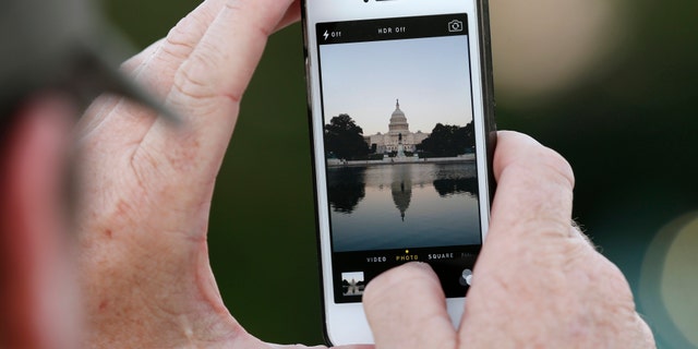 A man takes a photo of the U.S. Capitol, on the eve of a potential federal government shutdown, in Washington September 30, 2013. As many as a million government employees were making urgent plans on Monday for a possible midnight shutdown, with their unions urging Congress to strike a last-minute deal.
REUTERS/Kevin Lamarque (UNITED STATES - Tags: POLITICS BUSINESS) - RTR3FGGG