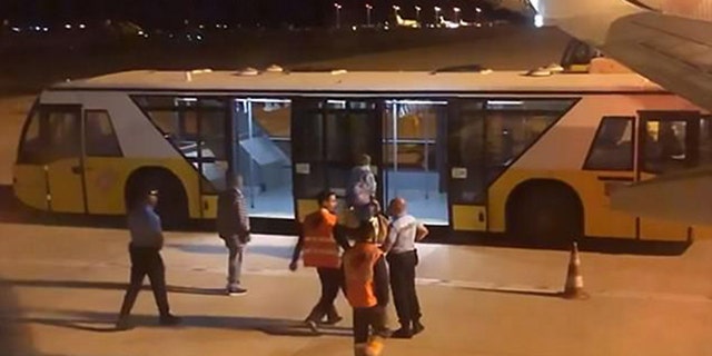 The man was taken off the plane and placed on a bus by medical personnel.