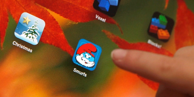 Sawyer Rummelhart, 4, points to the "The Smurf's Village" app on his mother's iPad at his family's home in Gridley, Calif.