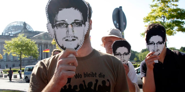 Protesters hold masks depicting former U.S. National Security Agency contractor Edward Snowden during a demonstration in Berlin May 22, 2014.
