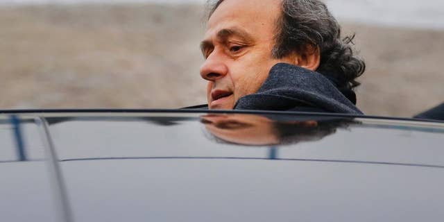 FILE - In this Jan. 19, 2015 file photo UEFA President Michel Platini gets into a car after a visit to the football arena in Minsk, Belarus. On Thursday, Oct. 8, 2015 file photo FIFA provisionally banned UEFA President Michel Platini for 90 days. (AP Photo/Sergei Grits)