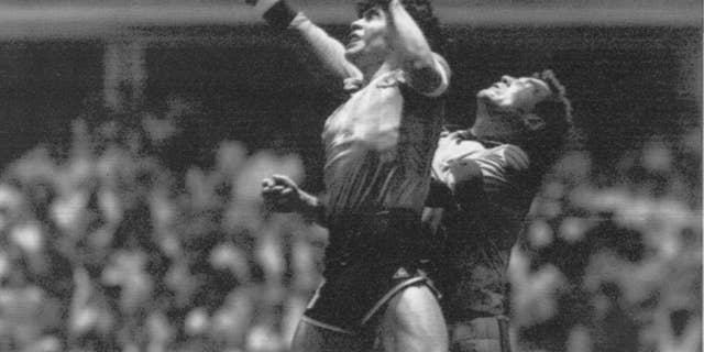 FILE - In this June 22, 1986 file photo Argentina's Diego Maradona, left, beats England goalkeeper Peter Shilton to a high ball and scores his first of two goals in a World Cup quarterfinal soccer match, in Mexico City. On this day: This was the day of the “Hand of God,” when Maradona used his left fist to knock a ball past England's Shilton. (AP Photo/El Grafico, Buenos Aires, File)
