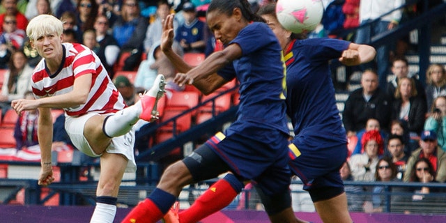 July 28, 2012: United States' Megan Rapinoe, left, shoots and scores the opening goal during the group G women's soccer match between the United States and Colombia at the London 2012 Summer Olympics in Glasgow, Scotland.