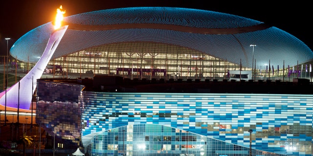 FILE - In this Thursday, Feb. 6, 2014 file photo, the Olympic cauldron, left, is lit during a test between the Bolshoy Ice Dome, top, and the Iceberg Skating Palace, foreground, in Sochi, Russia, prior to the start of the 2014 Winter Olympics. Westerners coming to Sochi for the Olympic games seemed surprised by the unfinished hotels, packs of stray dogs, and warnings not to drink the strange-colored water. But these vivid problems aside, the Olympics and ancillary development show some promising signs for the country. (AP Photo/Pavel Golovkin, File)