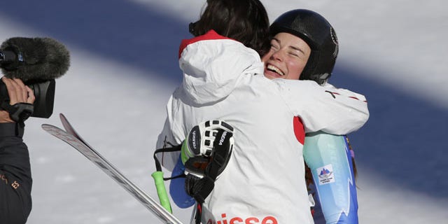 February 12, 2014: Slovenia's Tina Maze, right, and Switzerland's Dominique Gisin embrace after finishing the women's downhill at the Winter Olympics. (AP Photo/Gero Breloer)