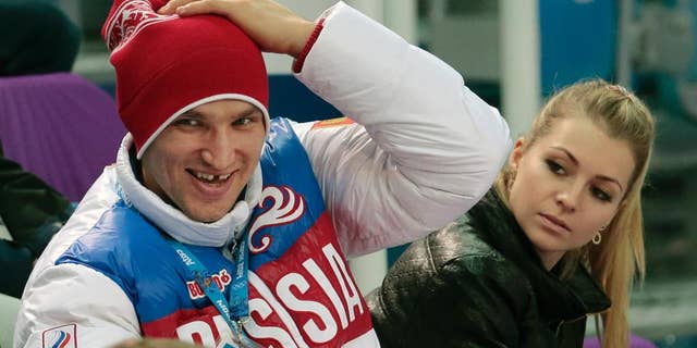 FILE - In this Tuesday, Feb. 11, 2014 file photo, Russian ice hockey player Alexander Ovechkin, left, and retired Russian tennis player Maria Kirilenko attend the pairs short program figure skating competition at the Iceberg Skating Palace during the 2014 Winter Olympics in Sochi, Russia. Russian tennis player Maria Kirilenko says she has broken off her planned wedding to Ovechkin of the Washington Capitals. The two had been together since 2011 and became engaged in December 2012. (AP Photo/Ivan Sekretarev, File)