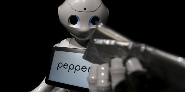SoftBank's human-like robot named "pepper" performs distributing a pack of tissue paper as a part-time worker during a news conference in Chiba, Japan, June 18, 2015.