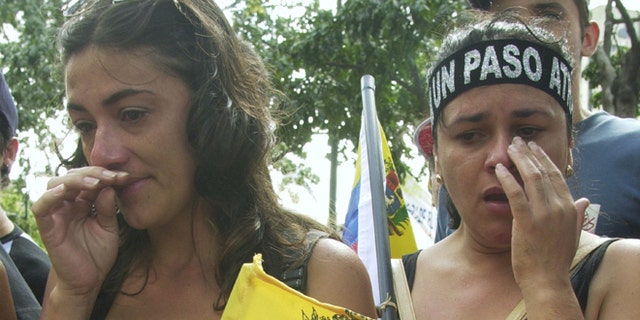 CARACAS, VENEZUELA - DECEMBER 7:  Two woman cry near the site where a demonstrator was killed December 7, 2002 at Plaza Francia in Caracas, Venezuela. The demonstrator was killed December 6, 2002 when gunmen opened fire during an opposition rally killing at least three and injuring 28.  (Photo by Oscar Sabetta/Getty Images)