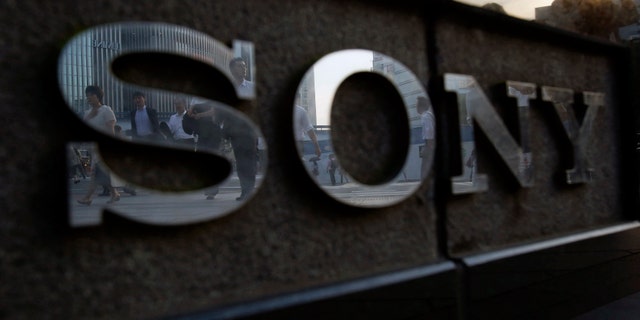File photo - Pedestrians are reflected in a logo of Sony Corp outside its showroom in Tokyo July 16, 2014.
