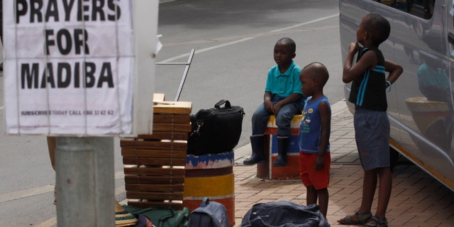 Dec 10, 2012 - Children hang out next to newspaper headline in tourist hub of Soweto South Africa, where Nelson Mandela once lived. Mandela is affectionately known as Madiba.