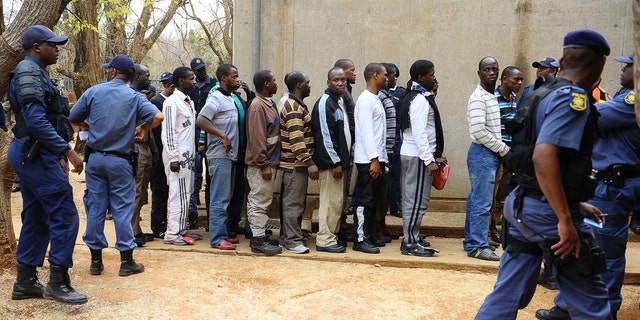 Aug. 27, 2012: Unidentified arrested mine workers await to be escorted into the court by police offers at the Ga-Rankuwa Magistrate Court in Pretoria, South Africa.