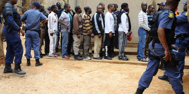 Aug. 27, 2012: Unidentified arrested mine workers await to be escorted into the court by police offers at the Ga-Rankuwa Magistrate Court in Pretoria, South Africa.