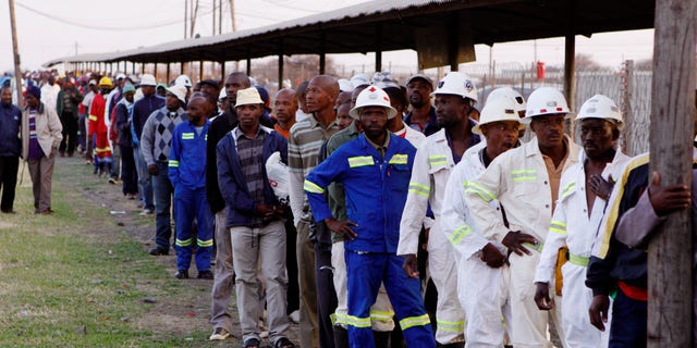 Miners return to work at the Lonmin Platinum mine after Lonmin resolved a five-week strike by agreeing to pay raises of up to 22 percent, in Marikana, Rustenburg, South Africa, Thursday, Sept. 20, 2012. (AP Photo/Denis Farrell)