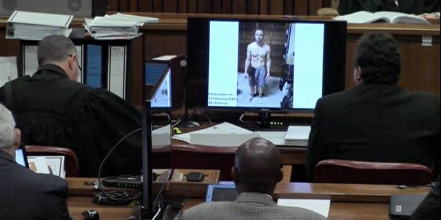 A police photograph of Oscar Pistorius standing on his blood-stained prosthetic legs and wearing shorts covered in blood.