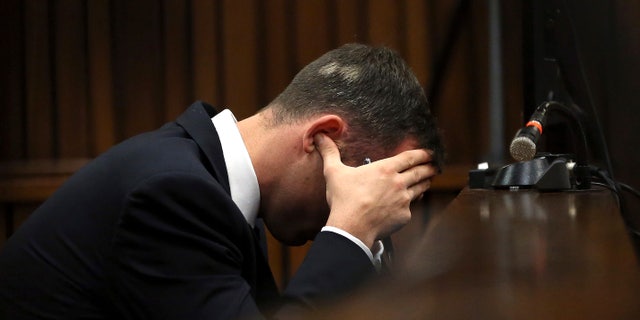 March 19, 2014: Oscar Pistorius, cradles his head in his hands as he listens to ballistic evidence being given in the court during his murder trial in Pretoria, South Africa.