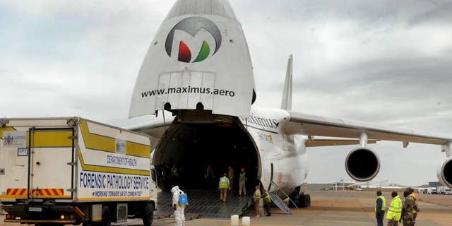 In this hand photo supplied by the government's Department's of Communications (DoC) one of four Forensic Pathology Services truck carrying the remains of some of the victims of the Nigeria building collapse, exits a chartered plane on it's arrival from Nigeria, in Pretoria, South Africa, at the Waterkloof Air Force base Sunday, Nov. 16, 2014. The remains of 74 South Africans who died in he building collapse on Sept. 12, 2014 arrived back in South Africa ahead of a ceremony at which the names of the dead were read to mourners. (AP Photo/Department of Communications) NO ARCHIVE