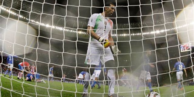 Italy goalkeeper Gianluigi Buffon, center, goes to pick up the ball after a penalty goal by Paraguay's Antolin Alcaraz, as fellow team members pile on top of him to celebrate, at left, during the World Cup group F soccer match between Italy and Paraguay in Cape Town, South Africa, Monday, June 14, 2010. (AP Photo/Roberto Candia)