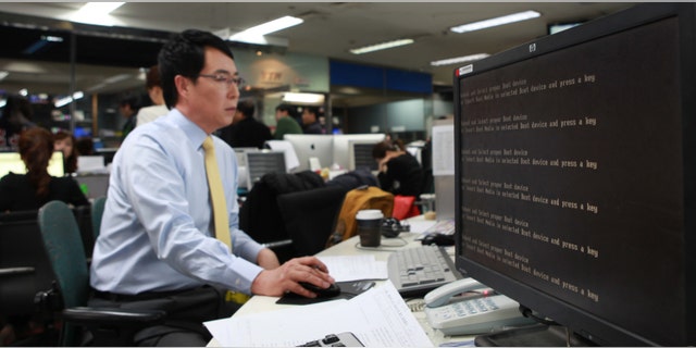 March 20, 2013: An employee works near a computer screen with error message at the newsroom of the all-news cable channel YTN as the broadcaster's computer network was paralyzed in Seoul, South Korea.