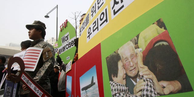 February 24, 2014: With a picture of South and North Korean family's reunion on display, protesters stage a rally denouncing the annual joint military exercises, dubbed Key Resolve and Foal Eagle, between South Korea and the United States, near the U.S. Embassy in Seoul, South Korea. (AP Photo/Ahn Young-joon)