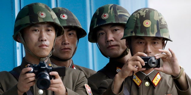 In this Saturday, July 27, 2013 photo, North Korean soldiers watch the southern side with cameras at the border village of Panmunjom, which has separated the two Koreas since the Korean War, in Paju, South Korea. (AP Photo/Lee Jin-man)