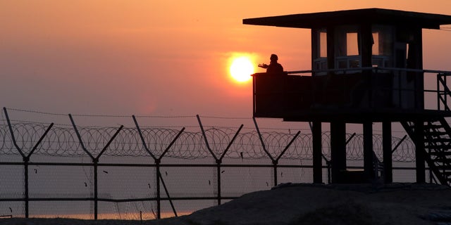 April 2, 2014 - A South Korean soldier guards with his gun at a guard post at sunrise on Baengnyeong Island, South Korea, near the West Sea border with North Korea.