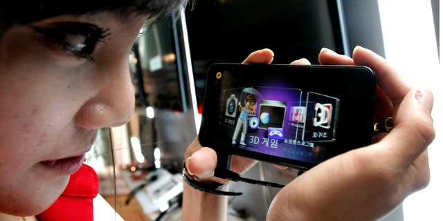 July 7, 2011: A model looks at an LG Electronics Optimus 3D phone during a press conference in Seoul, South Korea.