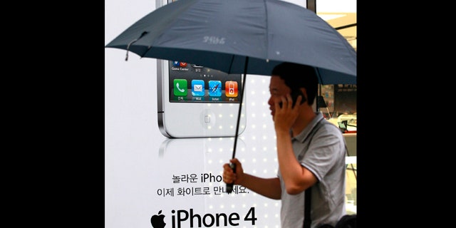 Aug. 17, 2011: A man passes by an Apple iPhone advertisement at downtown Seoul, South Korea. A group of nearly 27,000 South Koreans is suing Apple for $26 million for what they claim are privacy violations from the collection of iPhone user location information.