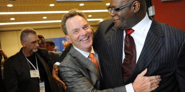 The Rev. Ronnie Floyd, center, of Cross Church in northwest Arkansas, hugs The Rev. Dwight McKissic, right, of Cornerstone Baptist Church in Arlington, Texas, after Floyd was elected the new president of the Southern Baptist Convention during its annual meeting Tuesday, June 10, 2014, in Baltimore. Floyd received 52 percent of votes cast by delegates to the annual meeting of the nation's largest Protestant denomination. (AP Photo/Steve Ruark)