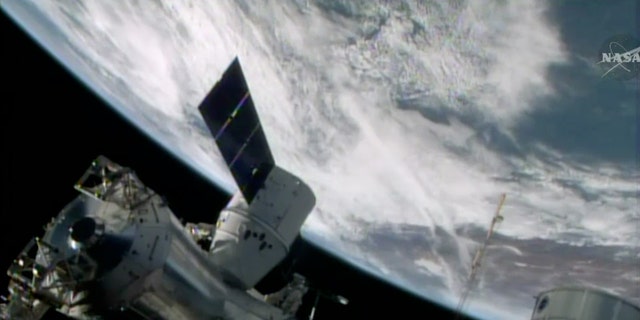 FILE- In this April 20, 2014, image made from a frame grabbed from NASA-TV, the SpaceX Dragon resupply capsule begins the process of being berthed on to the ISS.