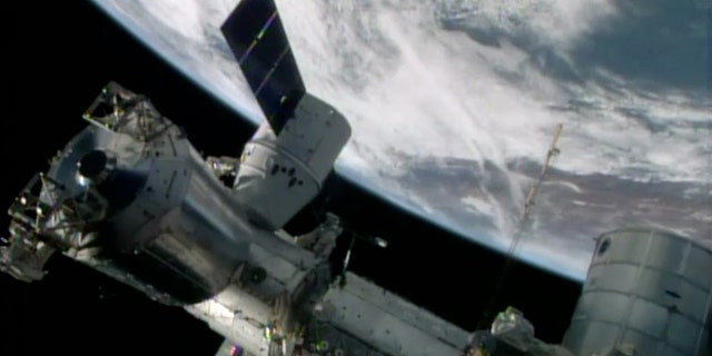 FILE- In this April 20, 2014, image made from a frame grabbed from NASA-TV, the SpaceX Dragon resupply capsule begins the process of being berthed on to the ISS.