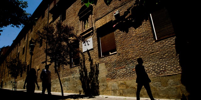 FILE - In this July 28, 2011 file photo, pedestrians walk by the closed order convent of the Trinitarias Descalzas, where the Spanish writer Miguel de Cervantes, author of El Quijojte, was buried in Madrid, Spain. His coffin and remains were lost during construction work at the church. (AP Photo/Daniel Ochoa de Olza, File)