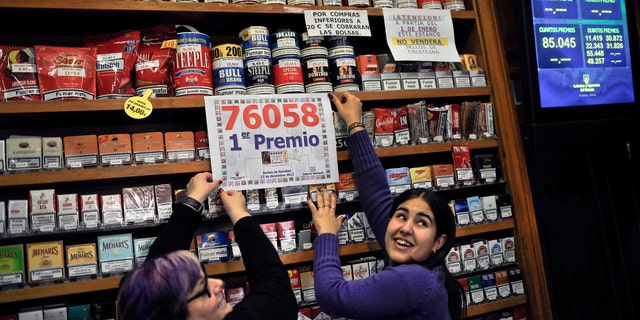Laura Leon, 30, right, and Pili Medina, 48,  who sold one of the winning lottery tickets with the numbers, 76058, of the top prize of Spain's Christmas lottery known as "El Gordo" or "The Fat One" number, celebrates this, in  her lottery shop,  in the small town of Tudela, northern Spain on Saturday Dec. 22, 2012, around 300 kilometers from Madrid.   (AP Photo/Alvaro Barrientos)