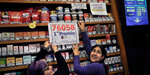 Laura Leon, 30, right, and Pili Medina, 48, who sold one of the winning lottery tickets with the numbers, 76058, of the top prize of Spain's Christmas lottery known as "El Gordo" or "The Fat One" number, celebrates this, in her lottery shop, in the small town of Tudela, northern Spain on Saturday Dec. 22, 2012, around 300 kilometers from Madrid. (AP Photo/Alvaro Barrientos)