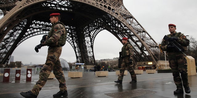 PARIS, FRANCE - JANUARY 09: Armed security patrols around the Eiffel Tower on January 9, 2015 in Paris, France. A huge manhunt for the two suspected gunmen in Wednesday's deadly attack on Charlie Hebdo magazine has entered its third day. (Photo by Dan Kitwood/Getty Images)