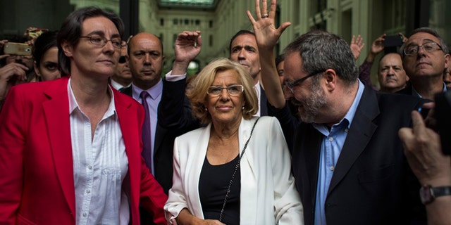 Madrid's new Mayor and member of Ahora Madrid (Madrid Now) party, Manuela Carmena, centre, meet the crowd in Madrid, Spain, Saturday, June 13, 2015. Spain's biggest cities, Madrid and Barcelona, are expected to swear in far-left mayors Saturday, and the radical leaders promise to cut their own salaries, halt homeowner evictions and eliminate perks enjoyed by the rich and famous. (AP Photo/Andres Kudacki)