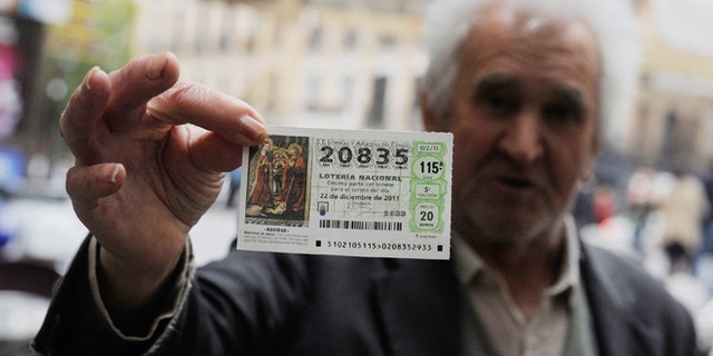 MADRID, SPAIN - NOVEMBER 09: A man holds a Christmas 'El Gordo' lottery ticket he is hoping to sell on November 9, 2011 in Madrid, Spain. The current Eurozone debt crisis has left Spain with crippling economic problems. Mounting debts, record unemployment figures and the recent credit rating downgrade is leaving the country facing further economic stagnation. The people of Spain are preparing to go to the polls for a general election which will be held on November 20, 2011. (Photo by Denis Doyle/Getty Images)