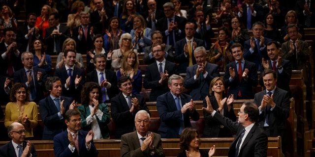 Spain acting conservative Prime Minister and Popular Party leader Mariano Rajoy, right, is greeted by his party members after speaking at the investiture debate, a day before a first confidence vote in Madrid, Spain, Wednesday, Oct. 26, 2016.  The Spanish Parliament has started an investiture debate that is widely expected to end in the conservative Popular Party taking power later this week, ending 10 months of political deadlock during which a caretaker government has run the country. (AP Photo/Daniel Ochoa de Olza)