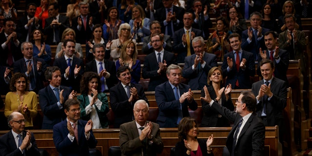 Spain acting conservative Prime Minister and Popular Party leader Mariano Rajoy, right, is greeted by his party members after speaking at the investiture debate, a day before a first confidence vote in Madrid, Spain, Wednesday, Oct. 26, 2016. The Spanish Parliament has started an investiture debate that is widely expected to end in the conservative Popular Party taking power later this week, ending 10 months of political deadlock during which a caretaker government has run the country. (AP Photo/Daniel Ochoa de Olza)