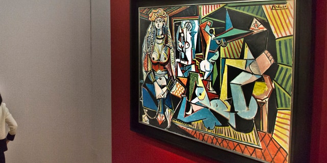 Visitors are introduced to the bronze sculpture "L'homme au doigt" by Alberto Giacometti, left, after viewing the Pablo Picasso oil painting "Les femmes d'Alger," right, during Christie's Spring 2015 Evening Sale press preview, Friday, May 1, 2015, in New York. New York City's spring art auctions get underway Tuesday with work from prominent artists fueling a robust market for impressionist, modern and contemporary art. (AP Photo/Bebeto Matthews)