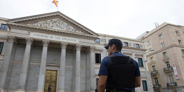 A police officer stands guard in front of the Spanish Parliament in Madrid, Spain, Tuesday, Aug. 30, 2016. Spain's acting Premier Mariano Rajoy is to start a two-day parliamentary debate later Tuesday ahead of a vote on his bid to form a minority government and end an eight-month political impasse, but the signs are he won't be successful. If he fails, he has another chance Friday when he only needs more votes in favor than against, but nothing indicates he can win that either. (AP Photo/Paul White)