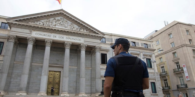 A police officer stands guard in front of the Spanish Parliament in Madrid, Spain, Tuesday, Aug. 30, 2016. Spain's acting Premier Mariano Rajoy is to start a two-day parliamentary debate later Tuesday ahead of a vote on his bid to form a minority government and end an eight-month political impasse, but the signs are he won't be successful. If he fails, he has another chance Friday when he only needs more votes in favor than against, but nothing indicates he can win that either. (AP Photo/Paul White)