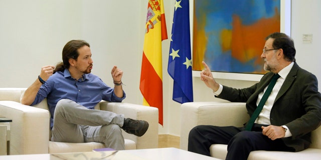 FILE - In this Oct. 30, 2015 file photo, Spain's Prime Minister Mariano Rajoy, right, talks to Podemos party leader Pablo Iglesias during their meeting at the Moncloa palace, the Spanish premier's official residence, in Madrid. Rajoy is meeting with the leaders of two upstart parties on Monday Dec. 28, 2015 following an election that gave Rajoys party the most votes but left it far short of a parliamentary majority. Rajoy is seeking support for his center-right Popular Party to govern as a minority party or in a coalition but his options are limited. (AP Photo/Francisco Seco, File)