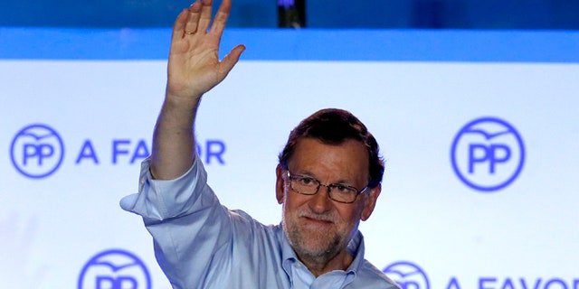 Spain's acting Primer Minister and candidate of Popular Party Mariano Rajoy, waves to his supporters as he celebrates the results of the party during the national elections in Madrid, Spain, Sunday, June 26, 2016. Spain's repeat election on Sunday failed to clarify the political future of the European Union's fifth-largest economy, with the main parties placing roughly the same as in last December's ballot, which brought six months of stalemate. (AP Photo/Daniel Ochoa de Olza)