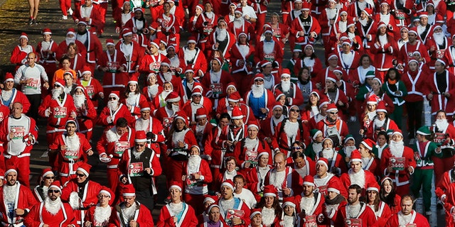 Revelers dressed as Santa Claus run during a "mini-marathon" in Madrid, Spain, Saturday, Dec. 14, 2013. Around 6,000 people dressed as Santa Claus and his elves have run a âmini-marathonâ through the streets of Madrid to promote festive cheer as the country tries to emerge from a two-year recession. While grown-ups dressed in red costumes with wispy white beards, children donned green elf outfits to run the 5.5 kilometer (3.4 miles) course through the city center. The race was organized Saturday by one of Spainâs leading department stores and it contributed 1 euro ($1.34) for each entrant to a charity that buys Christmas presents for deprived children around the world. (AP Photo/Andres Kudacki)