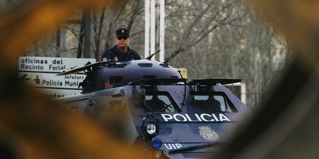 MADRID, SPAIN - FEBRUARY 15: A digger passes an armoured police vehicle at the Madrid National Court in the Casa de Campo, on the first day of the Madrid train bombings trial, on February 15, 2007 in Madrid, Spain. The March 2004 attack on commuter trains killed 119 and wounded 1,700 people. (Photo by Denis Doyle/Getty Images)