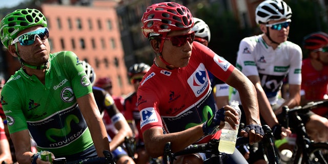 Sky's Team Christopher Froome of Britain, right, waits beside shirt race leader, Movistar's Team Nairo Quintana of Colombia, center, and team mate Alejandro Valverde of Spain, before the start of the 13th stage between Bilbao and Urdax Dantxarinea, 213,4 kilometers (132,6 miles), of the Spanish Vuelta cycling race that finish in Bilbao, northern Spain, Friday, Sept. 2, 2016. (AP Photo/Alvaro Barrientos)