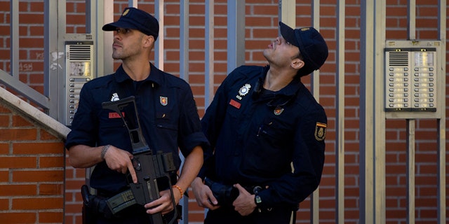 MADRID, SPAIN - JUNE 16:  Two Spanish policemen guard a residence at Rutilo street during an operation against an international Jihadist recruiting network on June 16, 2014 in Madrid, Spain. Spanish Police this morning made eight arrests in raids against an Islamist cell believed to be recruiting Jihadists to fight in Syria and Iraq for ISIL (Islamic State in Iraq and the Levant)Terrorist Group.  (Photo by Gonzalo Arroyo Moreno/Getty Images)